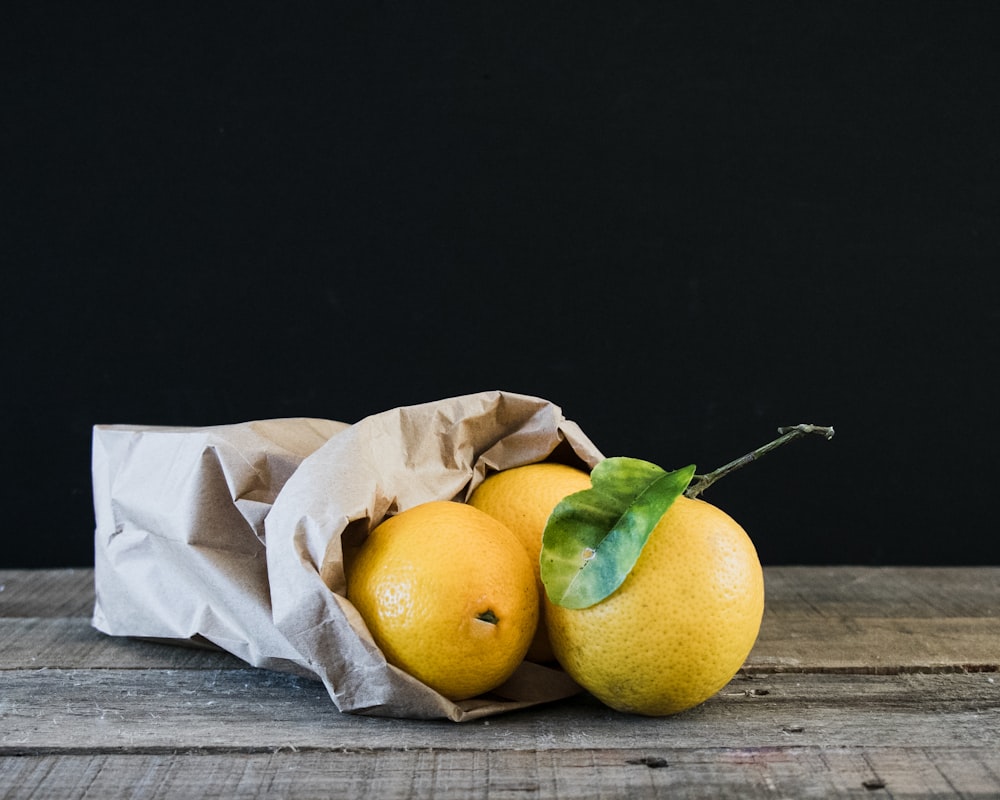 three yellow citrus fruits