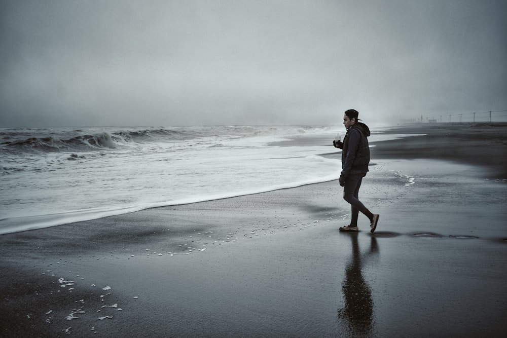 man standing in front of shoreline and body of water