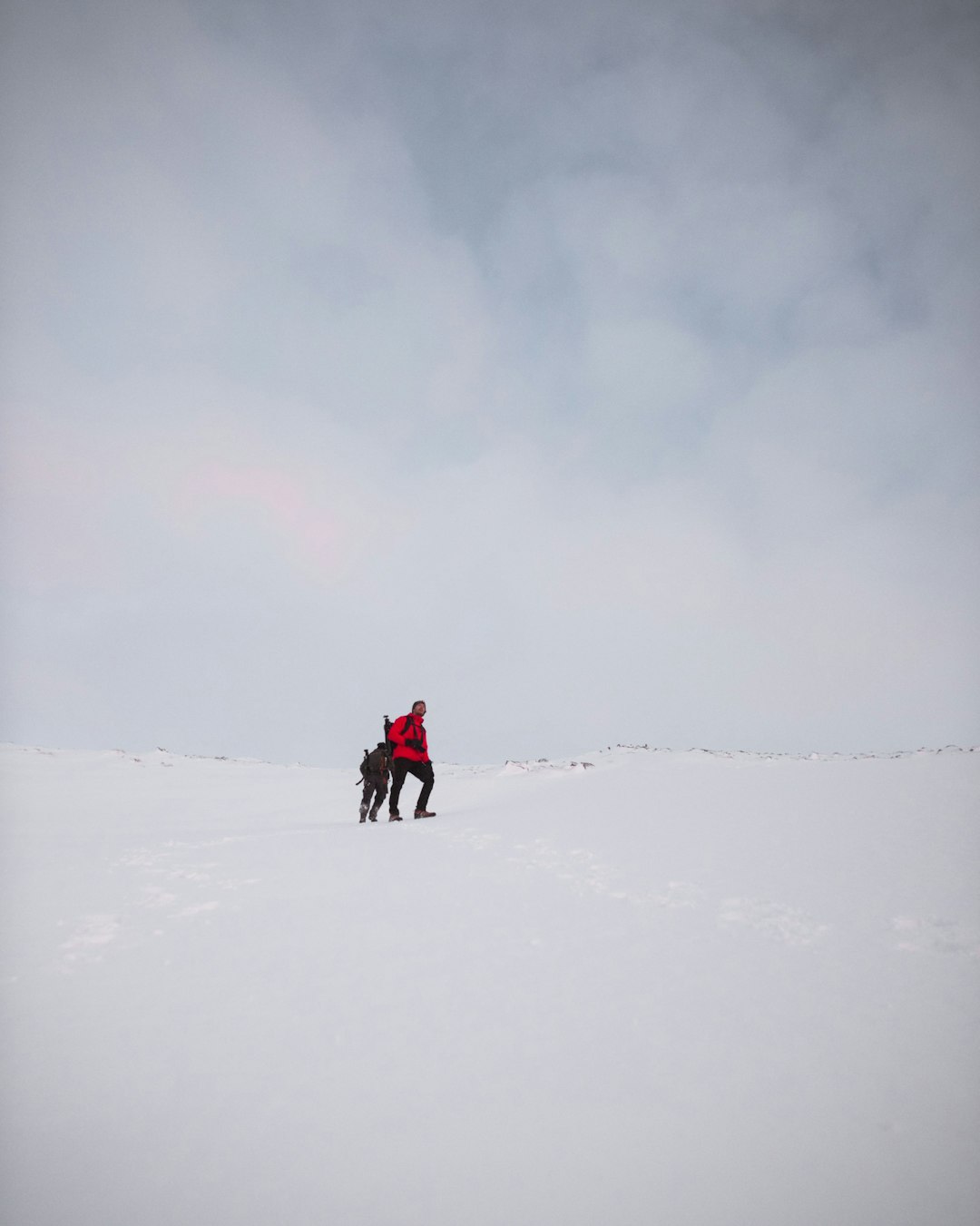 two men on snow field under cloudy sky
