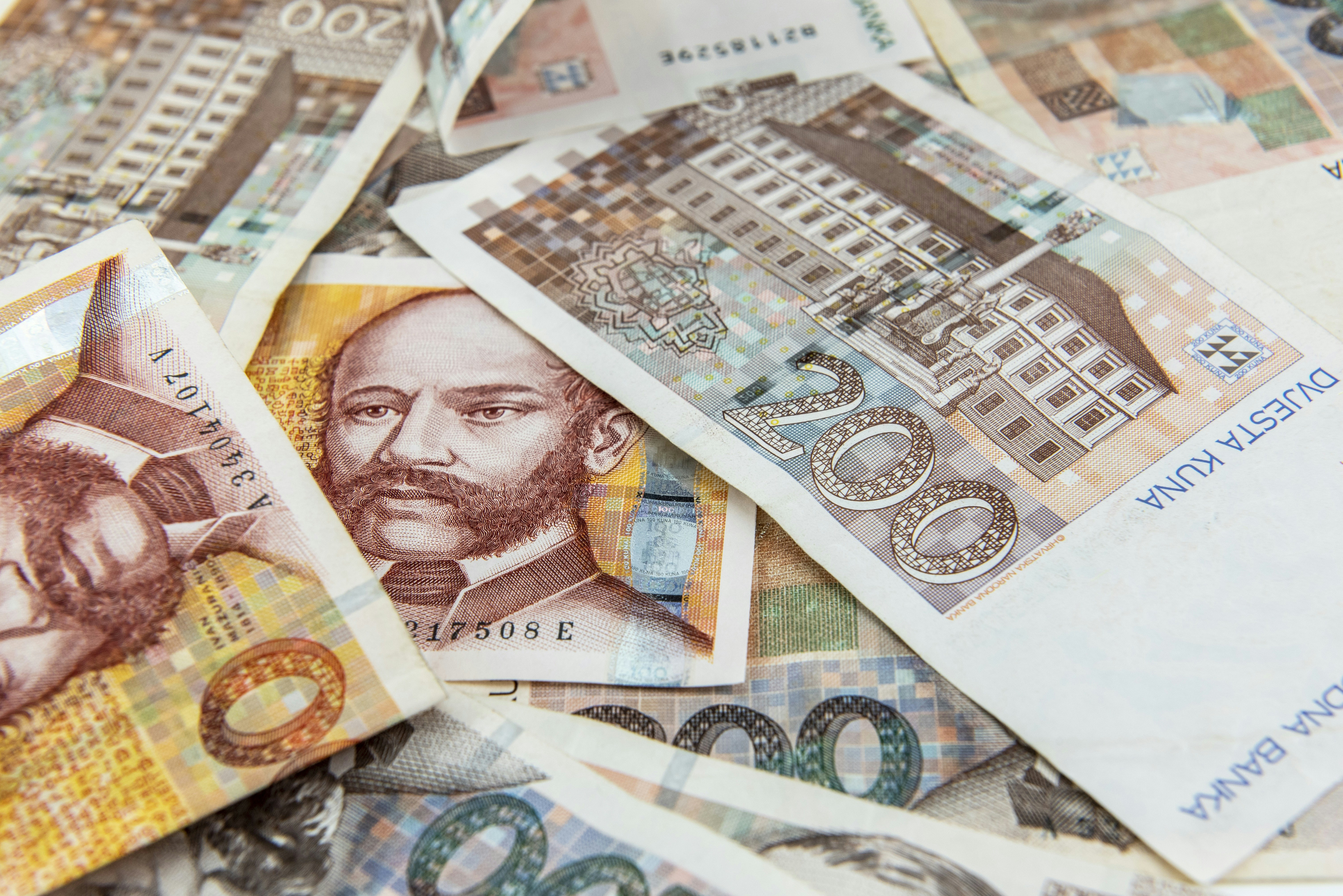 Varios billetes de alta denominación se encuentran apilados sobre una superficie plana de forma desordenada.