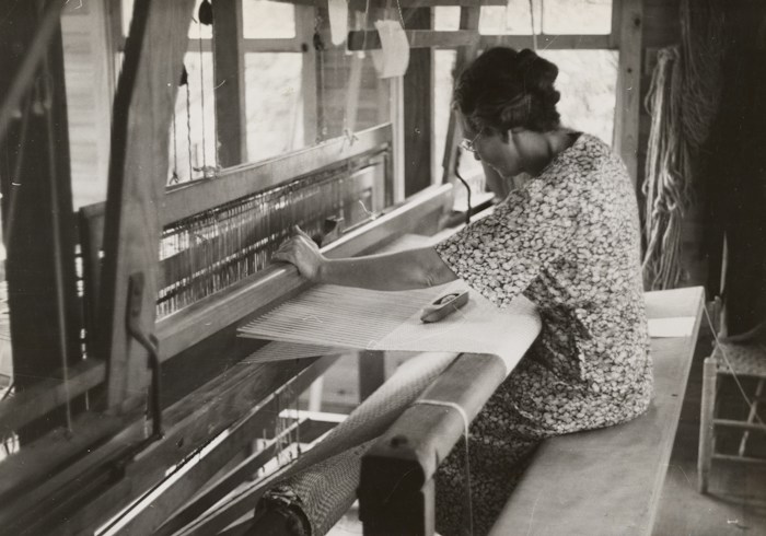 A weaver working at a floor loom