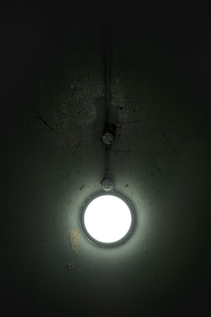 Close-up of a repaired drywall corner with a freshly hung light fixture above.