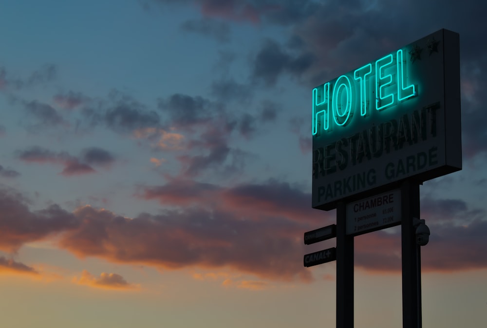 turned-on green hotel LED light signage ahead