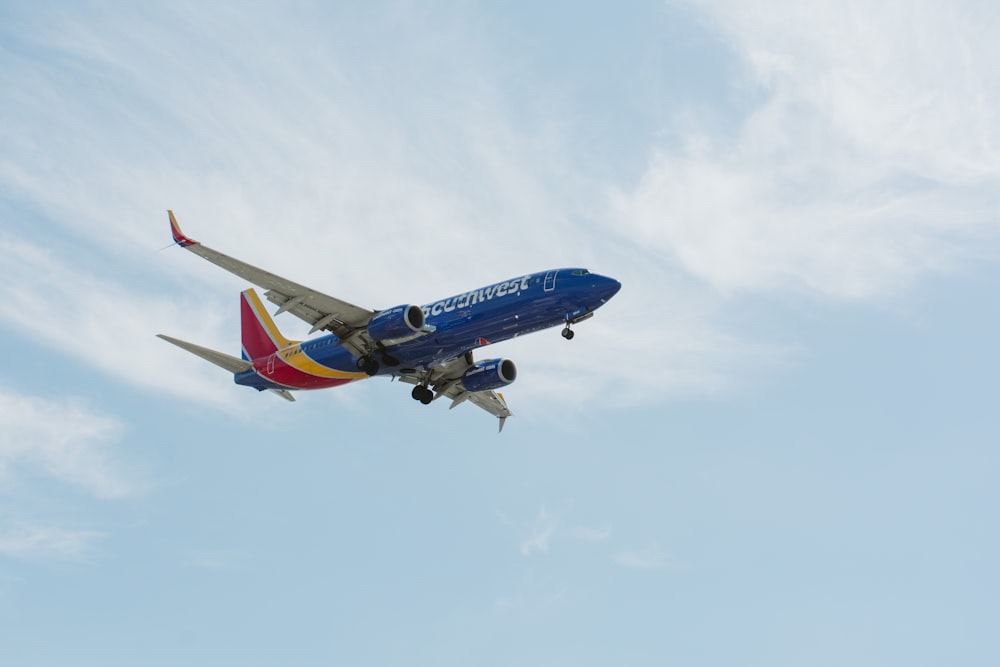 flying blue and red plane during daytime