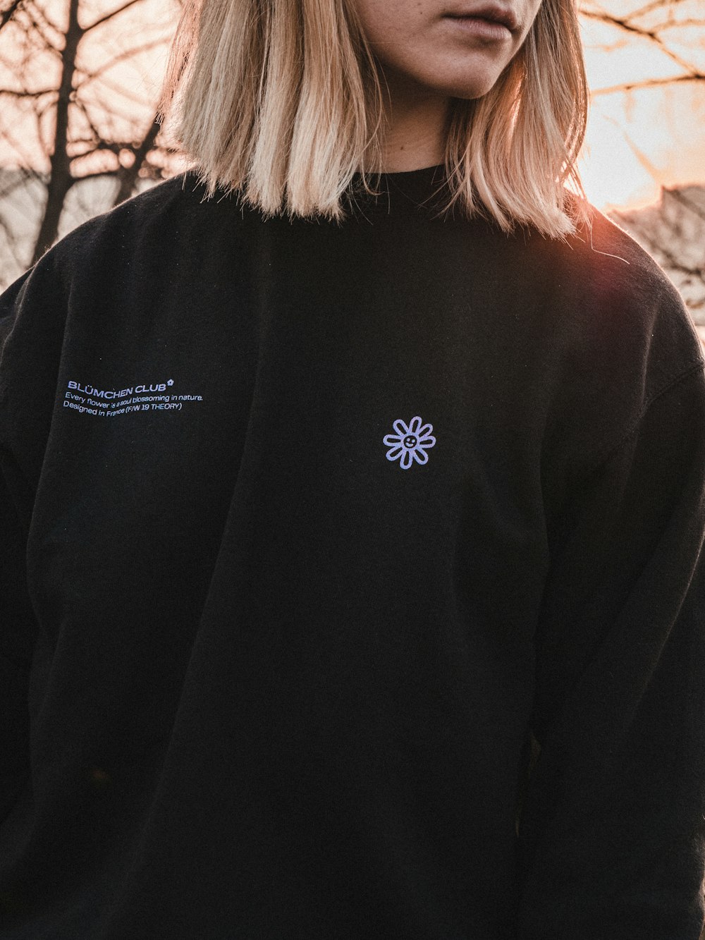 woman wearing black with white printed crew-neck sweatshirt standing while facing her left side