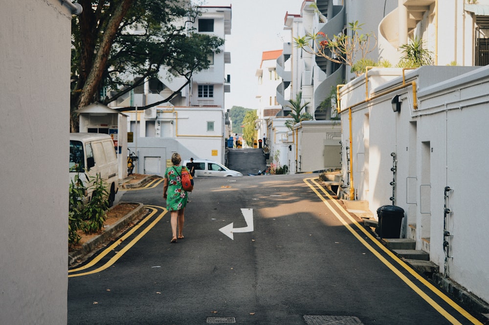 a woman in a green dress walking down a street