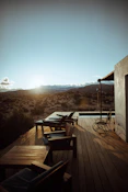 brown wooden armless chairs on balcony viewing field under blue and white sky