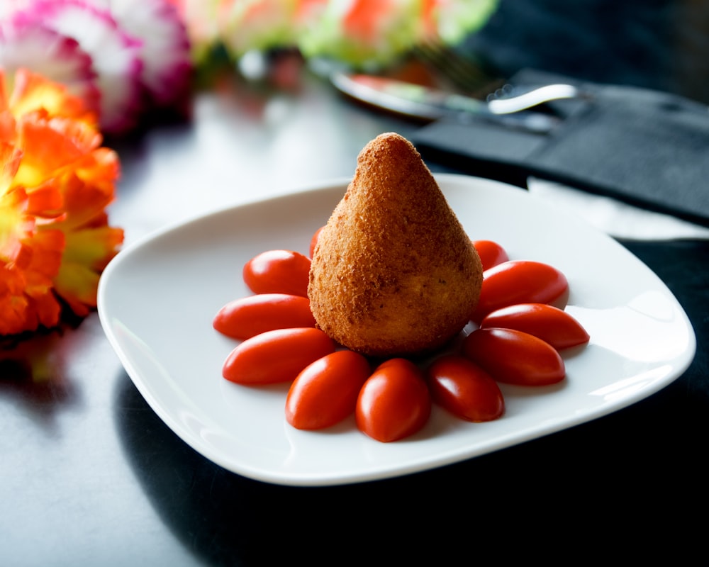 food with sliced tomato in a square plate