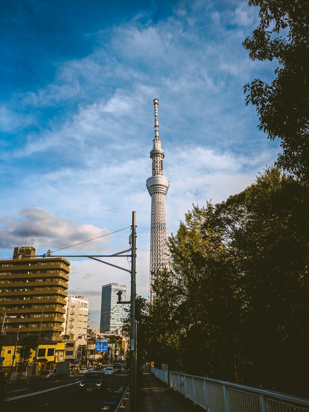 city with high-rise buildings and different vehicles on road under blue and white sky