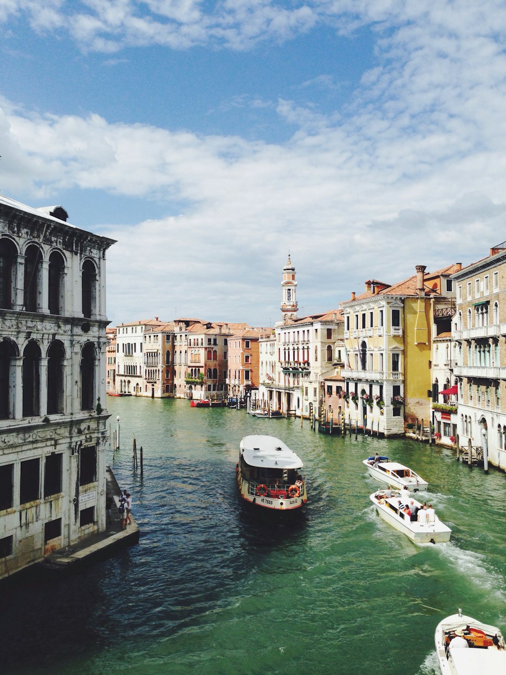 boats crossing on river between concrete structures