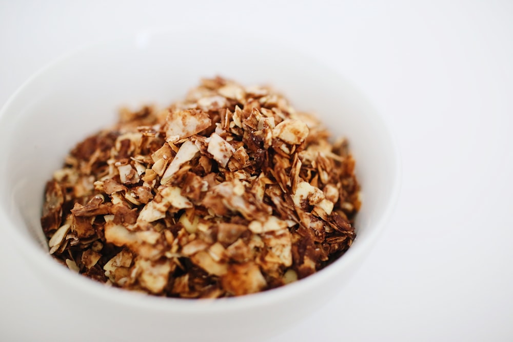 uma tigela branca cheia de granola em cima de uma mesa