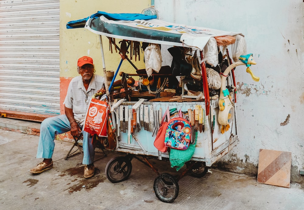 man sitting beside display cart