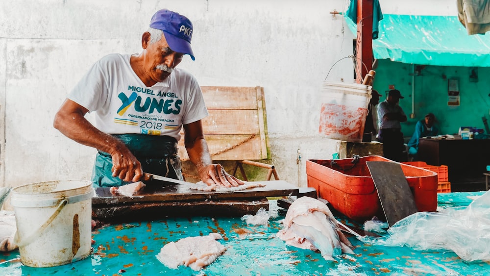 man holding knife slicing meat