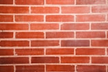 Close-up of a bricklayer carefully placing bricks on a wall.