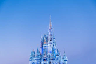 A majestic bounce house shaped like a castle, glowing warmly under soft evening lights.