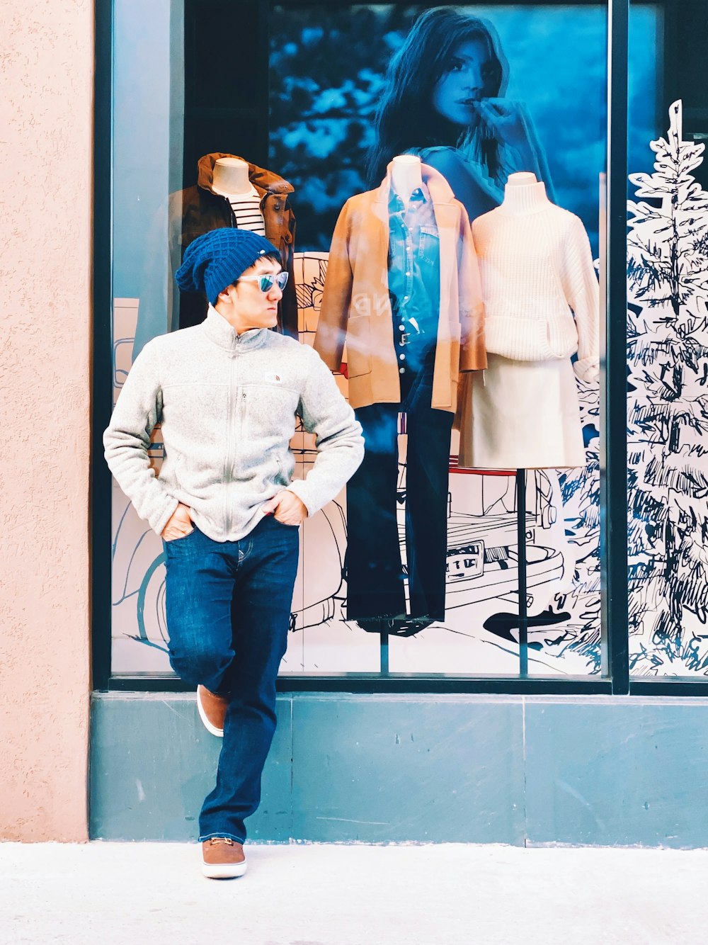 man leaning on dress shop window