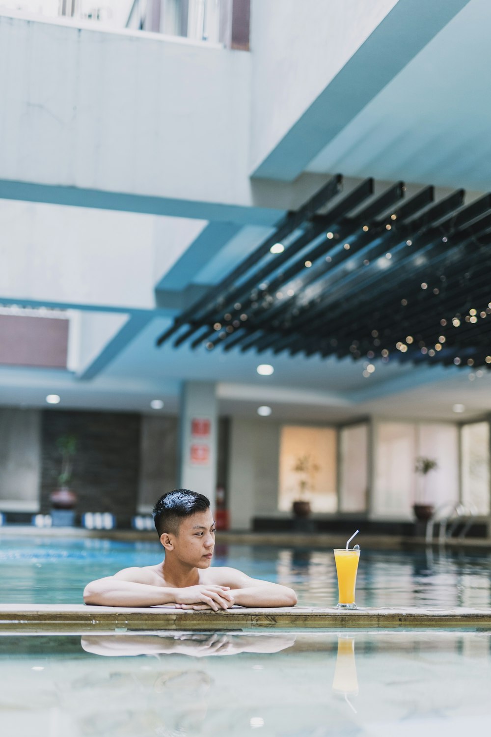 man in pool near mango juice during daytime