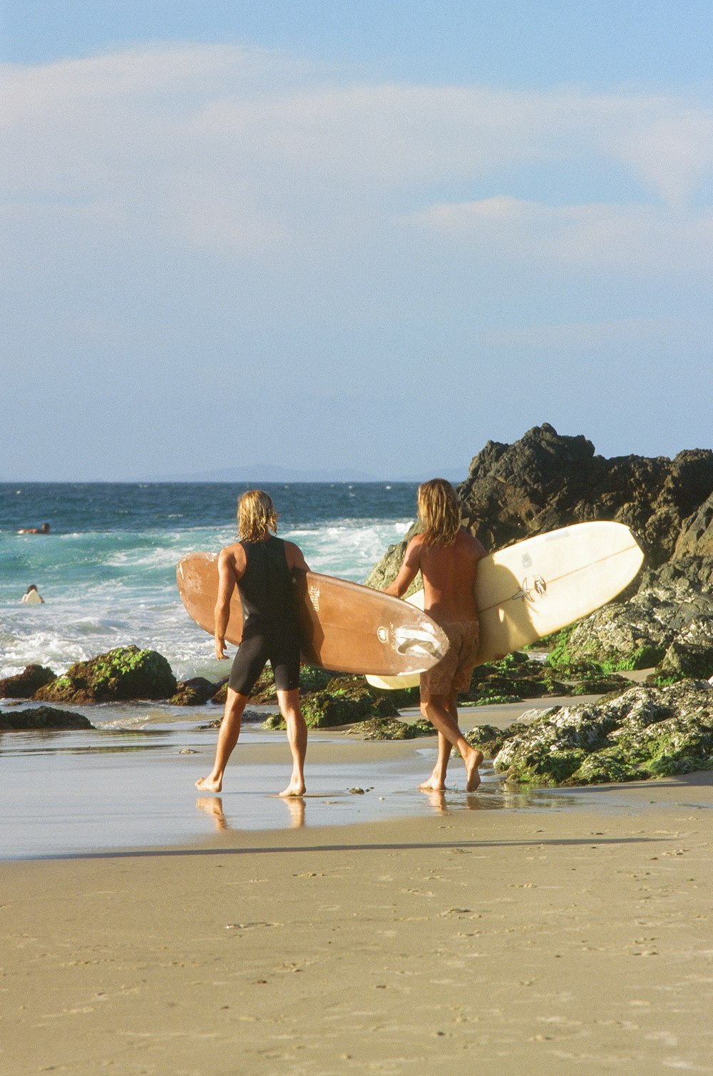 man and woman holding surfboard