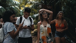 A group enjoying a guided hike through lush tropical forest with waterfalls in the background.