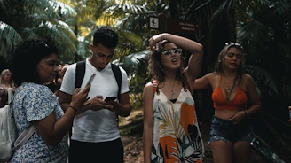 A group enjoying a guided hike through lush tropical forest with waterfalls in the background.