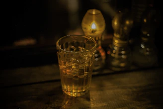 Warmly lit scene of a customer admiring a handcrafted whisky glass.