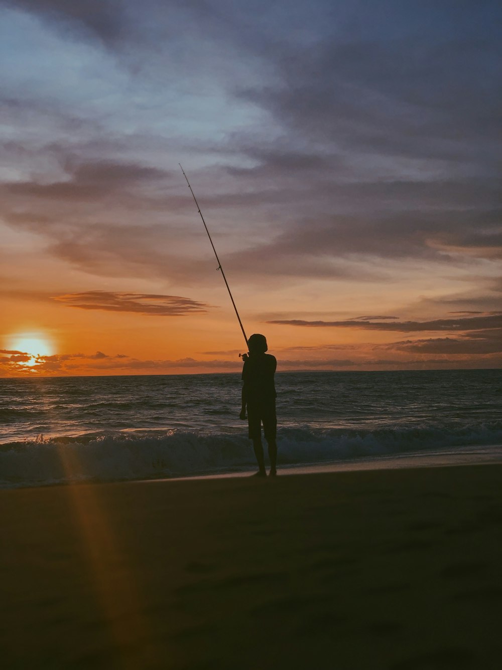 persona che tiene la canna da pesca