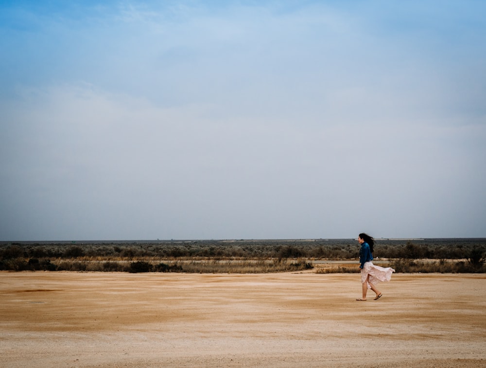 woman walking on brown field