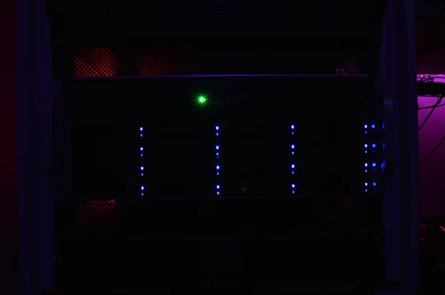 A modern server rack glowing with blue LED lights in a cool tech environment.