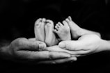 grayscale photo of person holding baby