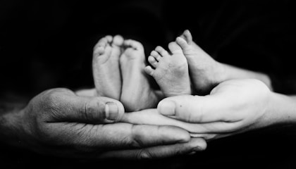 grayscale photo of person holding baby