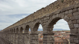 The majestic Segovia aqueduct stretching across the old town at sunset.
