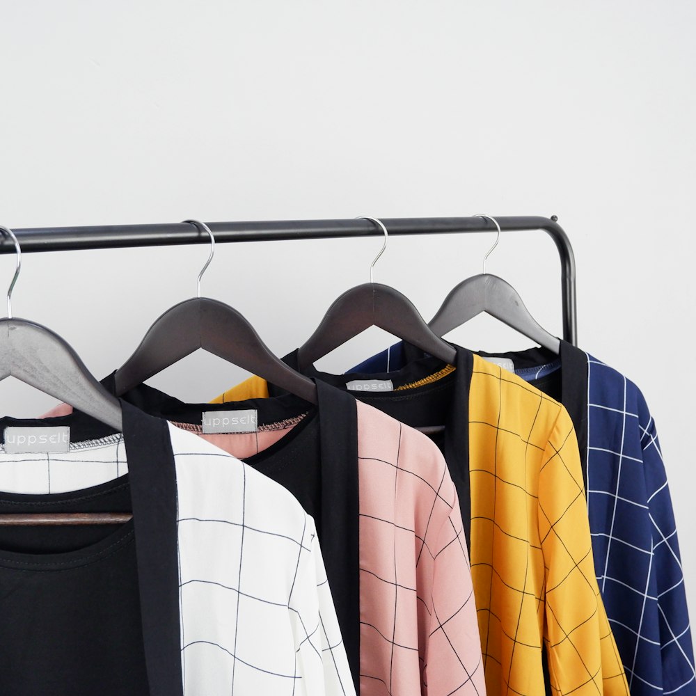 four several-colors grid print cardigans hanging on black clothes rack