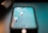 Two light bulbs with red bases are reflected on a smartphone screen. They are set against a backdrop with a turquoise hue.
