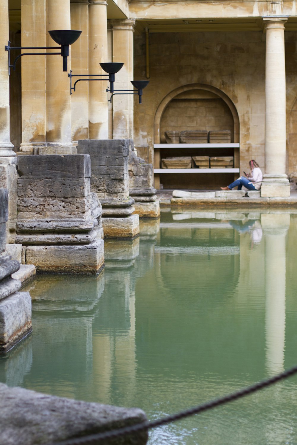 donna che si siede accanto allo specchio d'acqua