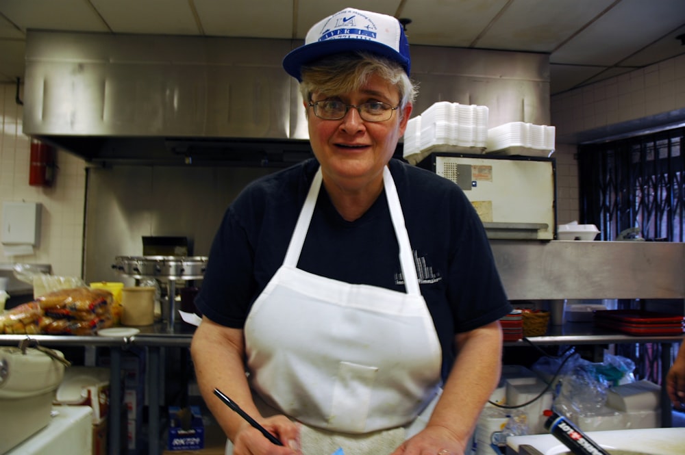 standing woman wearing apron holding pen