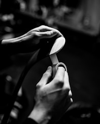grayscale photo of person holding flip flop