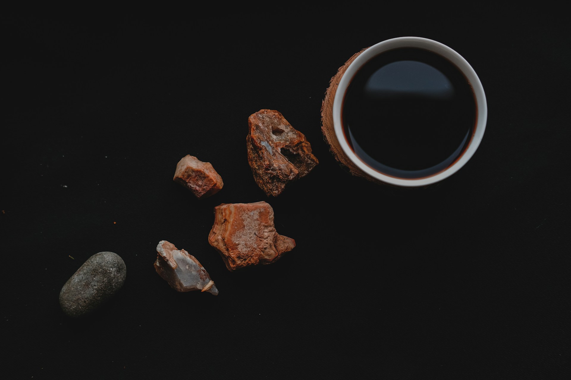 A minimalist still-life composition featuring a marble surface with a delicate coffee cup, a sleek MacBook, and soft natural light casting gentle reflections.