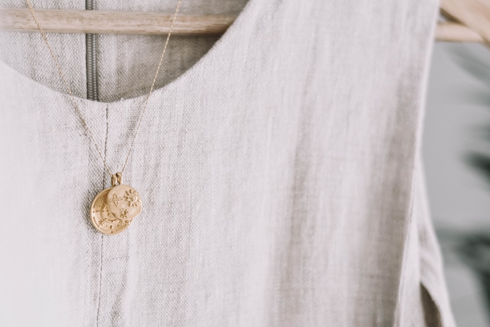 gold-colored pendant necklace on hanged dress