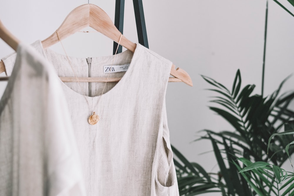 white crew-neck sleeveless top with gold-colored necklace