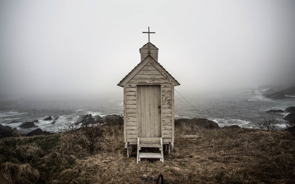 gray wooden shed on cliff