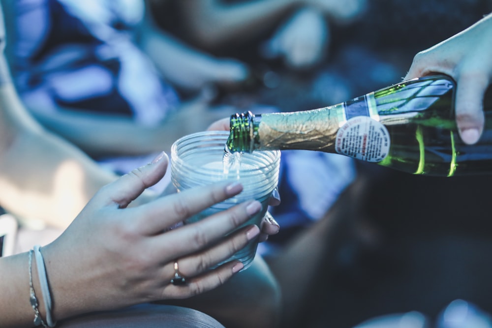 person pouring wine in cup