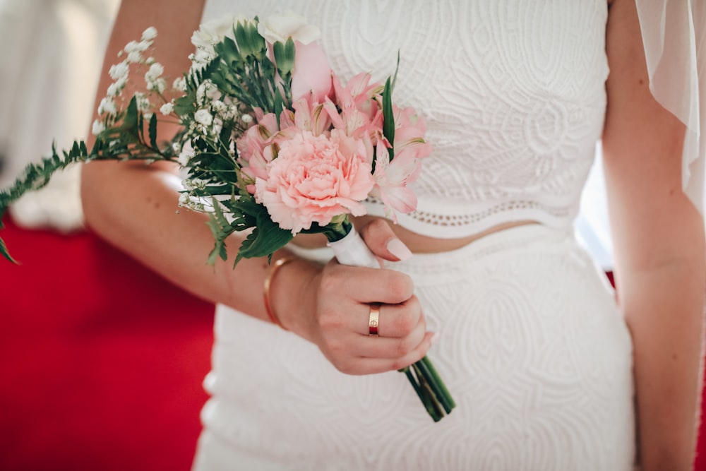 woman holding pink flowers