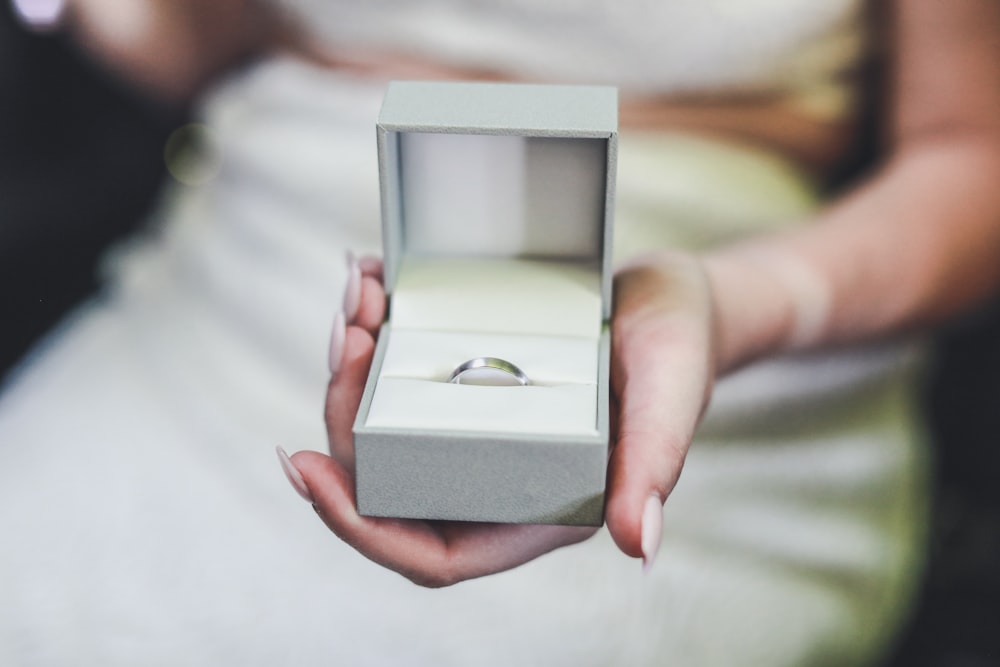 Photographie de mise au point sélective d’une femme tenant une boîte de bague