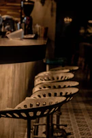 Vintage-style bar stools with metal frames and cushioned seats in a cozy pub setting.
