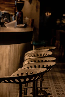 Vintage-style bar stools with metal frames and cushioned seats in a cozy pub setting.