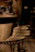 A rustic industrial iron bar stool placed beside a wooden workbench in a cozy workshop.