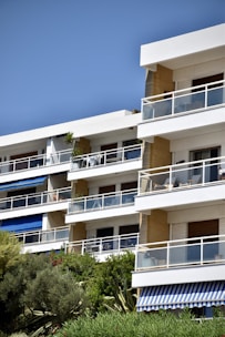 Photo of a modern apartment building with balconies and greenery.