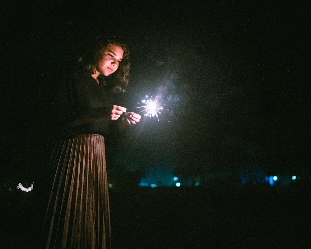 standing woman holding two sparklers