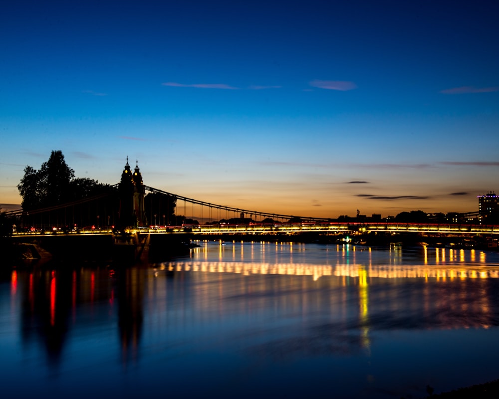 reflection of bridge light on body of water at night