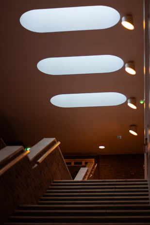 Emergency lights mounted along a stairwell in a residential building, casting a warm glow.
